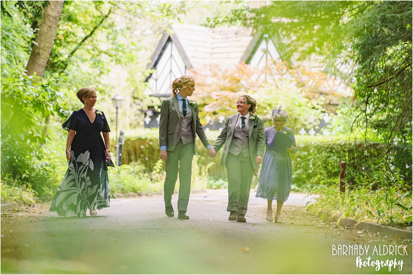 Same Sex couple walk to the wedding at Samlesbury Hall near Preston in Lancashire