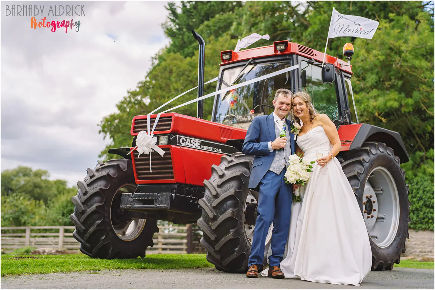 Wedding couple in front of their Massey Ferguson tractor at their wedding at The Pheasant in Harome, unusual fun country farming wedding transport idea 